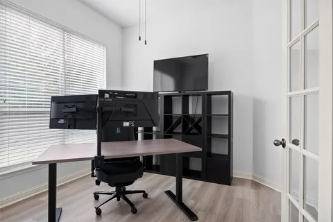 a bedroom with a bed and a flat tv screen on the dresser