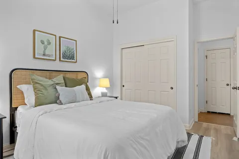 a bedroom with a bed and a painting on the wall