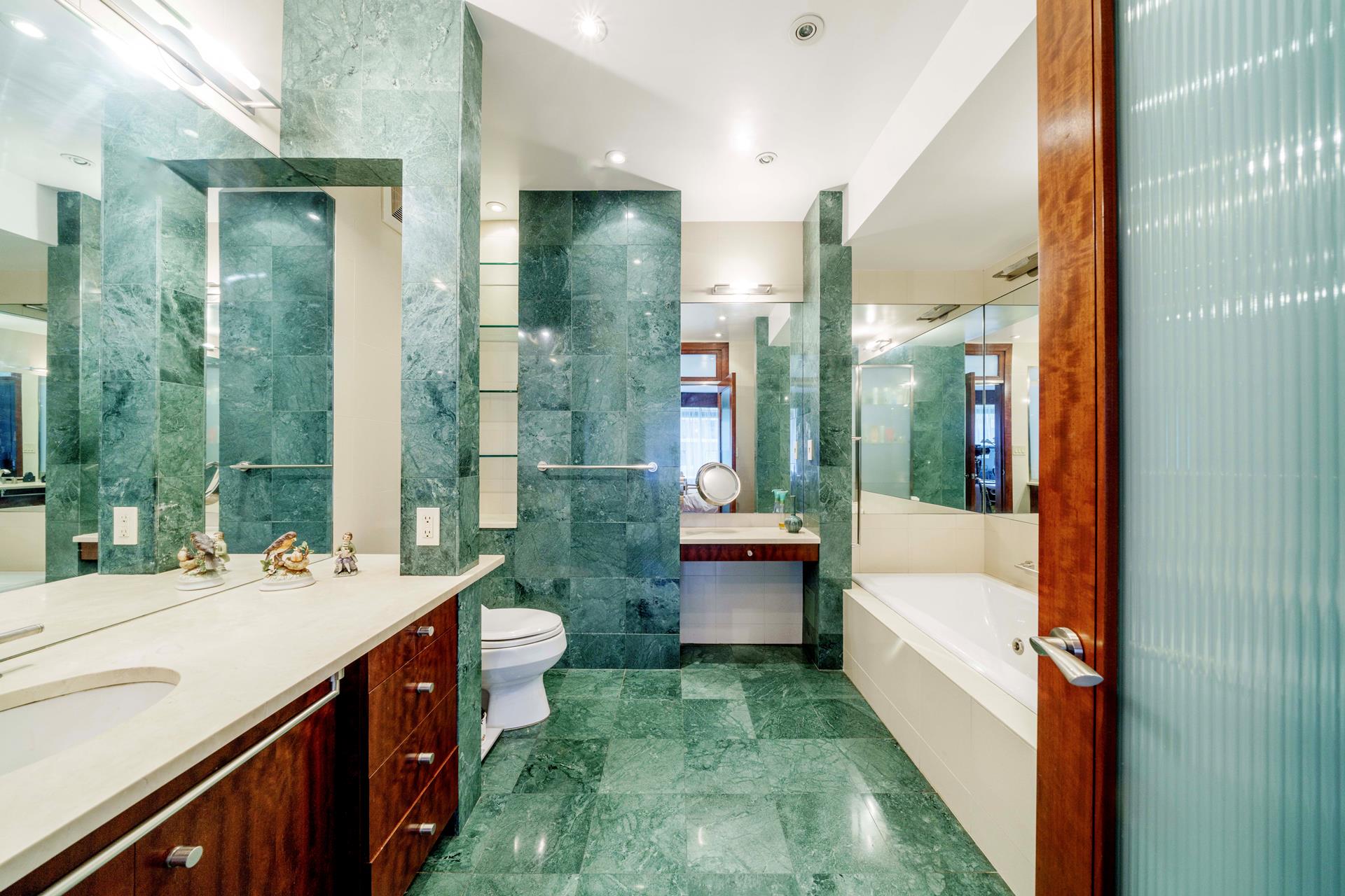 475 Park Avenue, Unit 11BC Manhattan, NY 10022 - Photo 9 of 15 a bathroom with a double vanity sink toilet and tub