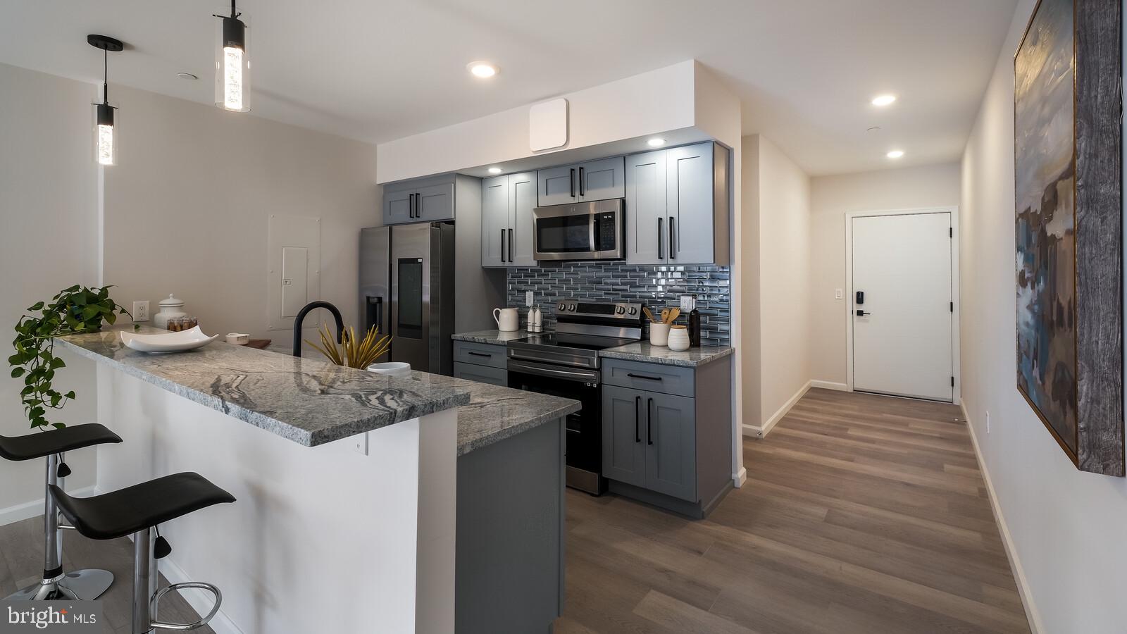 1825 Callowhill Street, Unit 504 Philadelphia, PA 19130 - Photo 2 of 49 a kitchen with stainless steel appliances kitchen island granite countertop a refrigerator and a sink