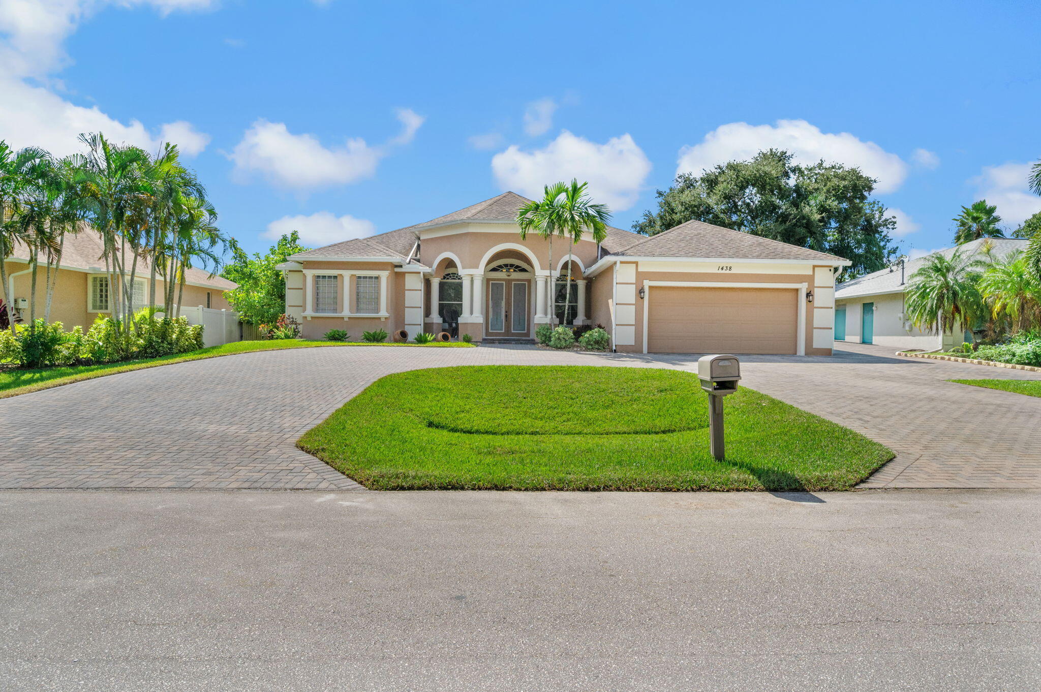 1438 Southwest Apache Avenue Port St. Lucie, FL 34953 - Photo 1 of 34 a front view of a house with a yard and trees