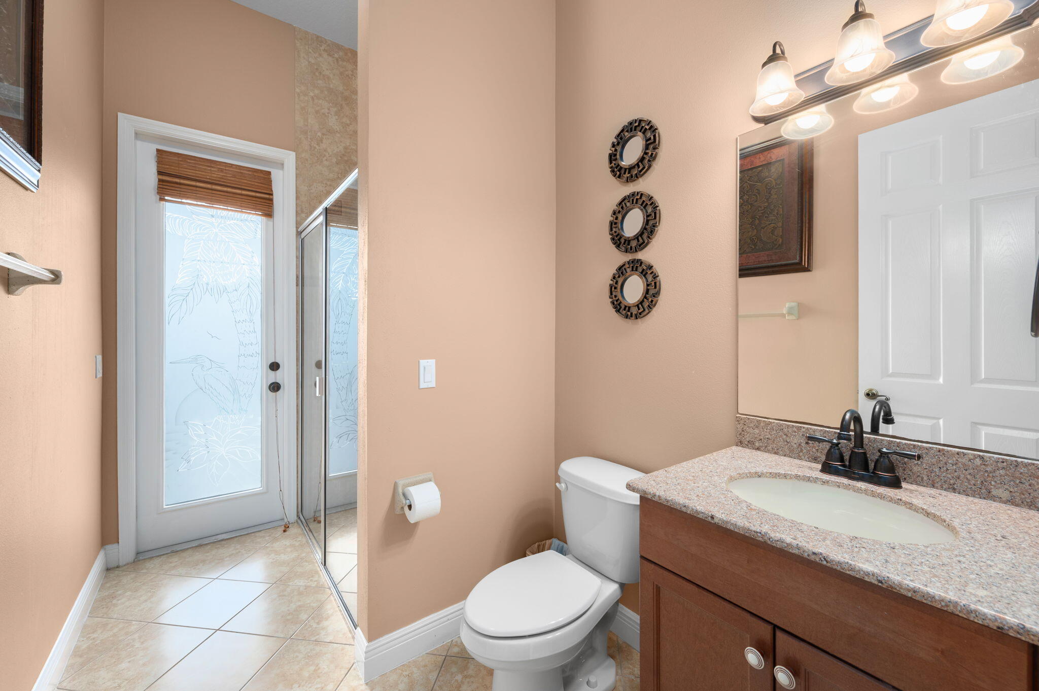 1438 Southwest Apache Avenue Port St. Lucie, FL 34953 - Photo 16 of 34 a bathroom with a granite countertop sink mirror vanity and toilet