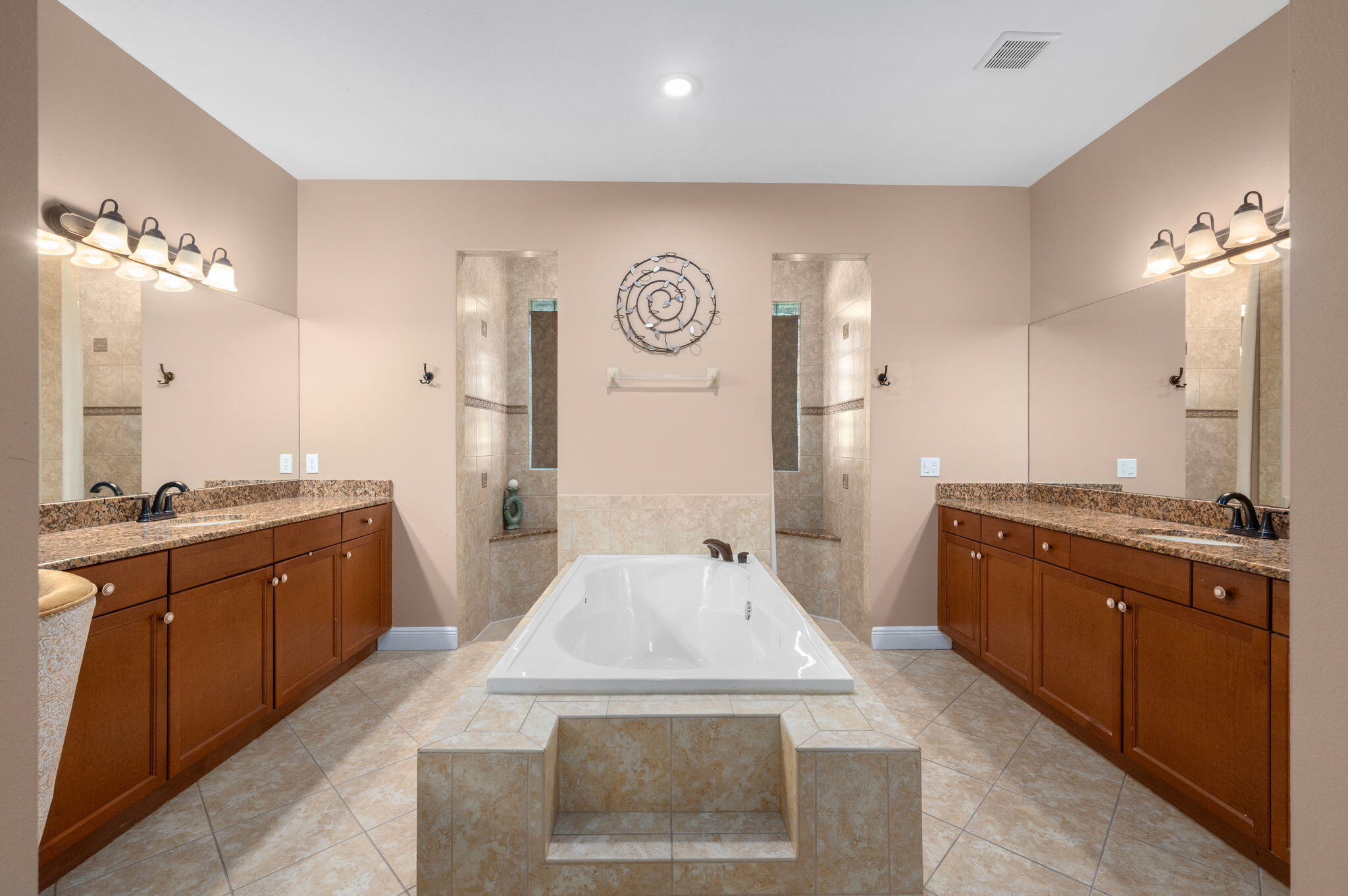 1438 Southwest Apache Avenue Port St. Lucie, FL 34953 - Photo 20 of 34 a spacious bathroom with a granite countertop sink a mirror and a bathtub