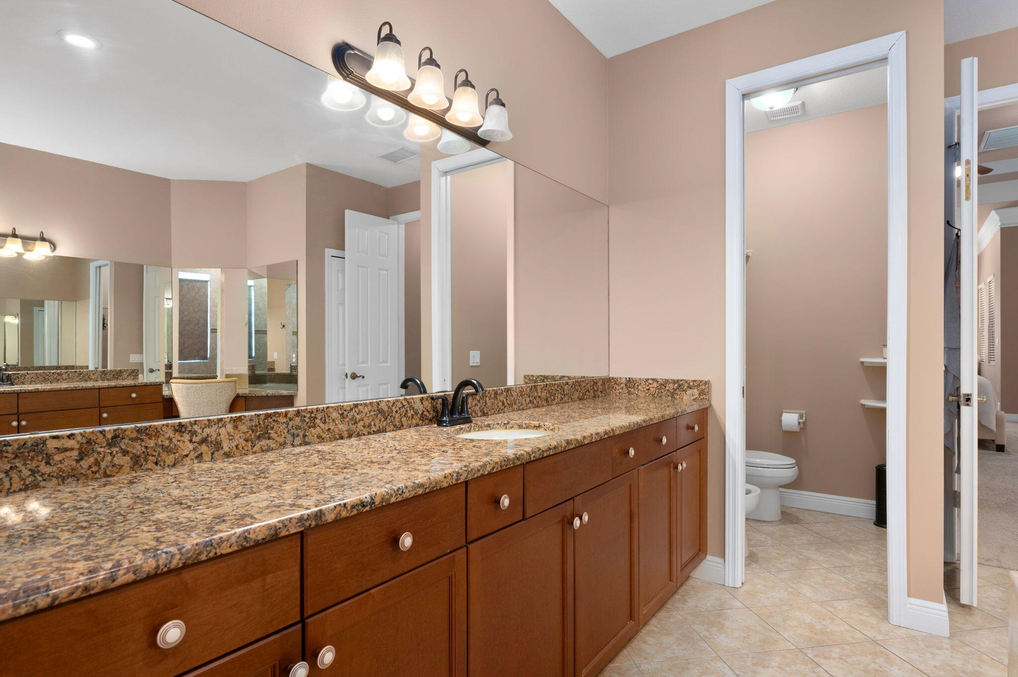 1438 Southwest Apache Avenue Port St. Lucie, FL 34953 - Photo 21 of 34 a bathroom with a granite countertop sink and a mirror