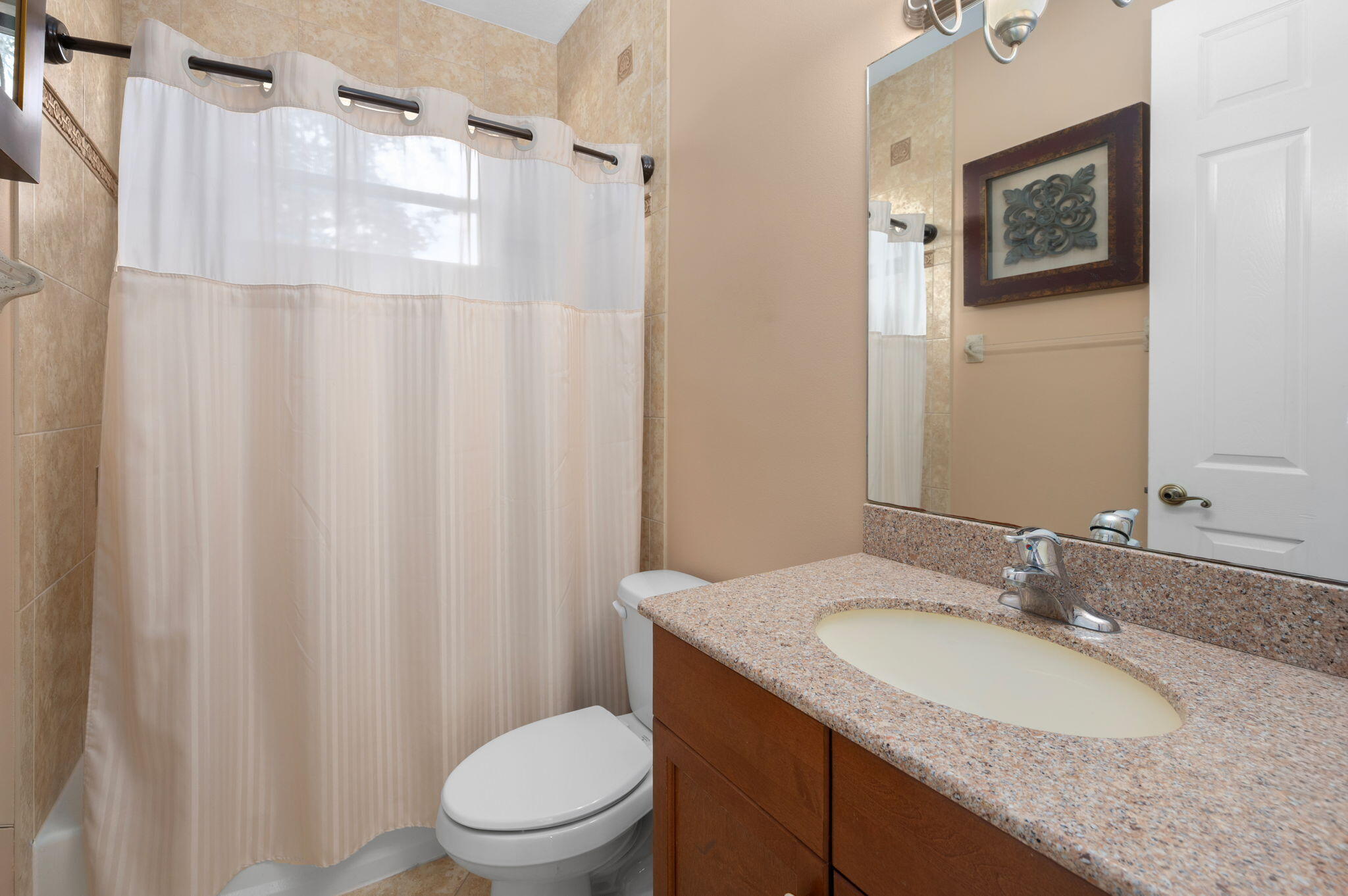 1438 Southwest Apache Avenue Port St. Lucie, FL 34953 - Photo 25 of 34 a bathroom with a granite countertop sink toilet and a mirror