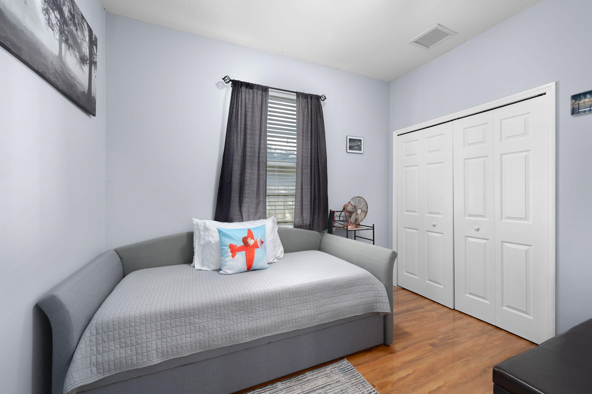 1438 Southwest Apache Avenue Port St. Lucie, FL 34953 - Photo 26 of 34 a bedroom with a bed and wooden floor