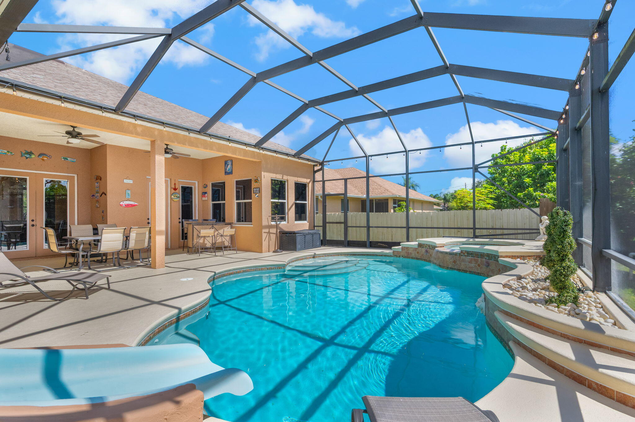 1438 Southwest Apache Avenue Port St. Lucie, FL 34953 - Photo 30 of 34 a view of a backyard with table and chairs under an umbrella