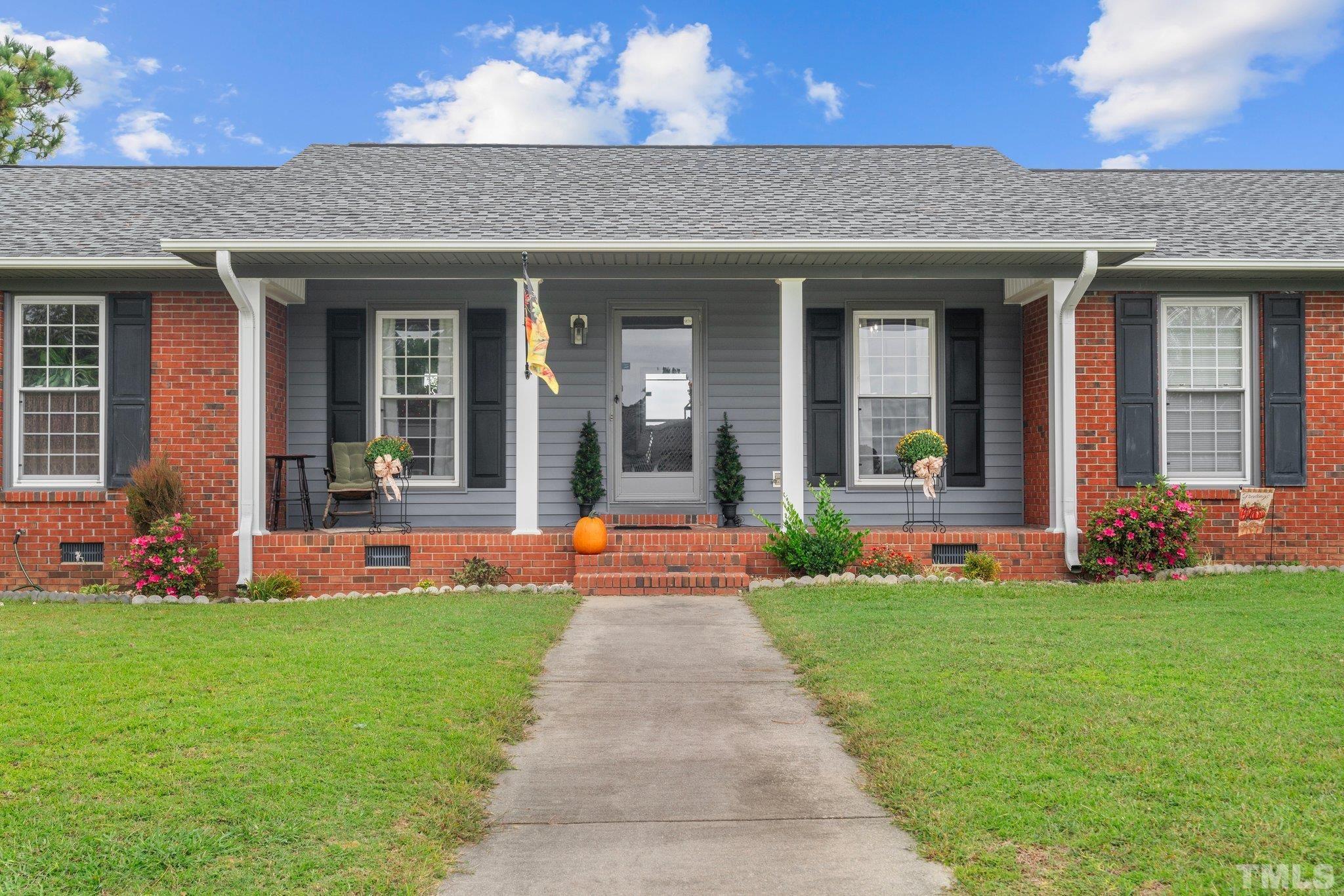 a front view of a house with a yard and fountain
