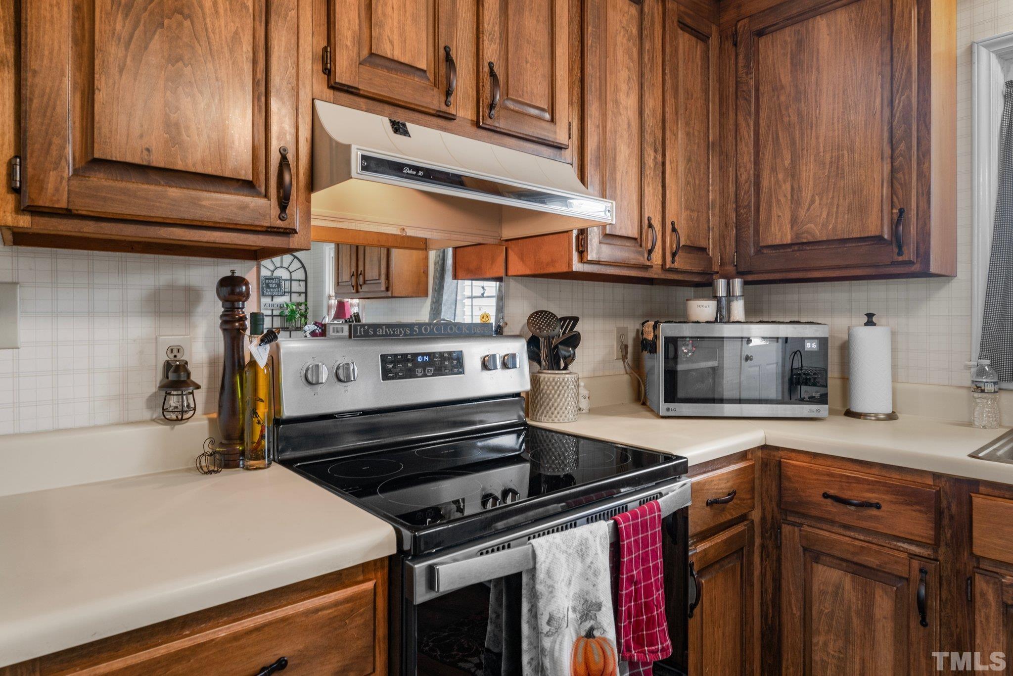 107 Murchison Drive Dunn, NC 28334 - Photo 13 of 37 a kitchen with stainless steel appliances granite countertop a stove and a microwave