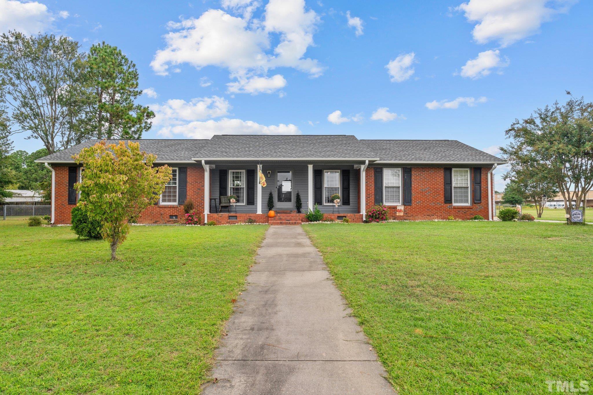 107 Murchison Drive Dunn, NC 28334 - Photo 2 of 37 a front view of a house with a garden and porch