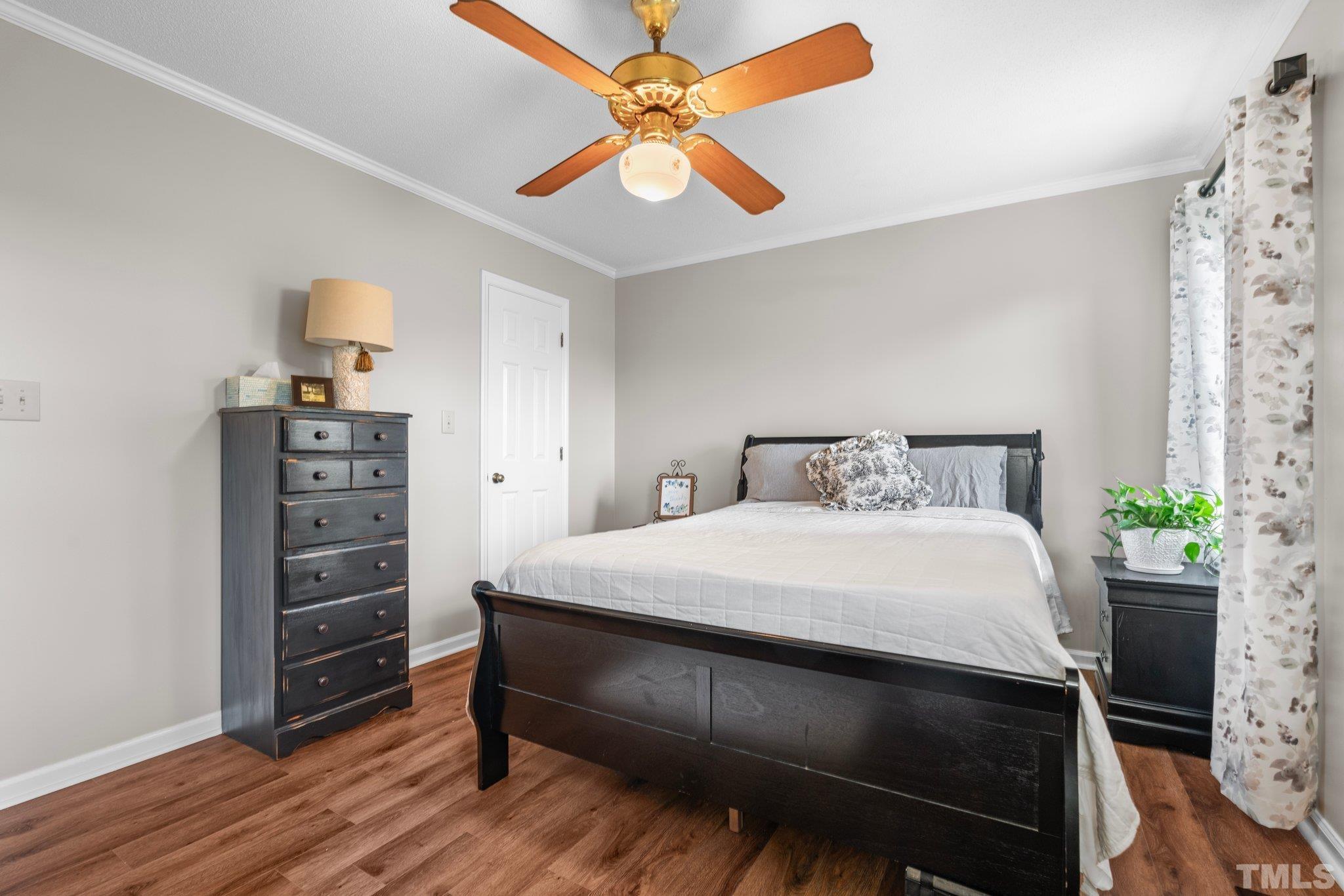 107 Murchison Drive Dunn, NC 28334 - Photo 25 of 37 a bedroom with a bed a dresser and a chandelier