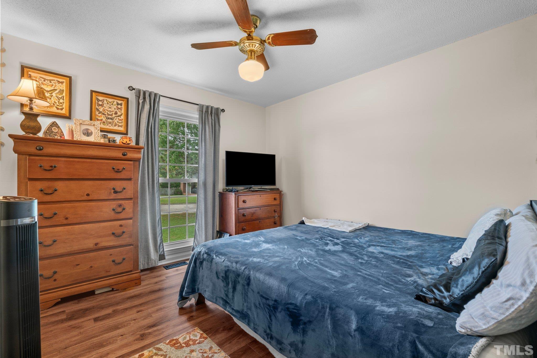 107 Murchison Drive Dunn, NC 28334 - Photo 27 of 37 a spacious bedroom with a bed and a flat screen tv
