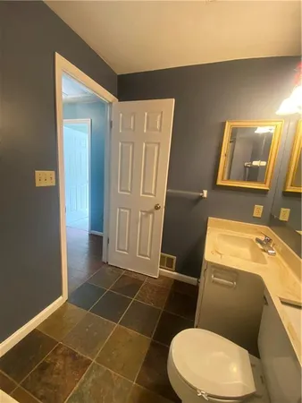 a bathroom with a granite countertop sink toilet and shower