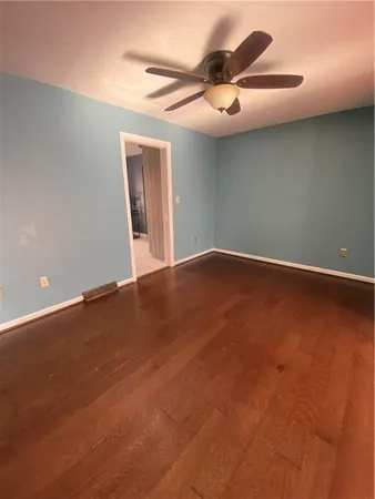 an empty room with a ceiling fan and window