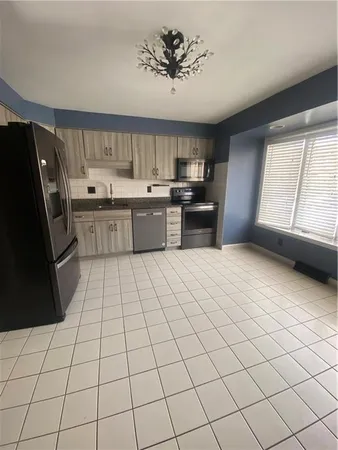 a kitchen with stainless steel appliances kitchen island granite countertop a sink cabinets and wooden floor