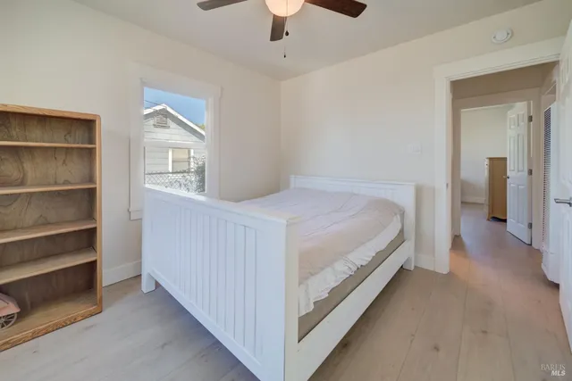 a bedroom with a bed and a ceiling fan