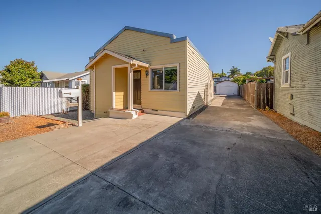a view of a house with backyard and a tree