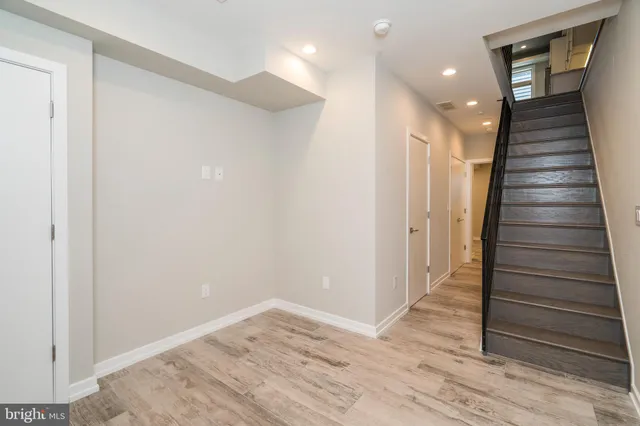 a view of hallway with stairs and wooden floor