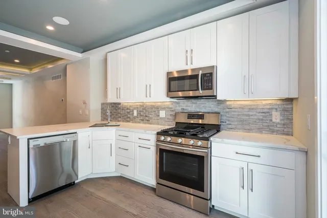 a kitchen with cabinets stainless steel appliances and a sink