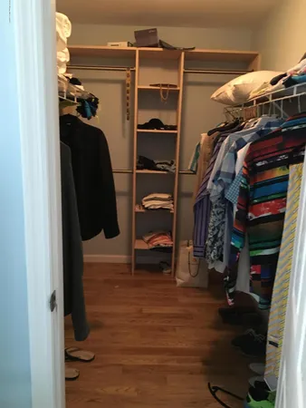 a view of walk in closet with clothes and shoes