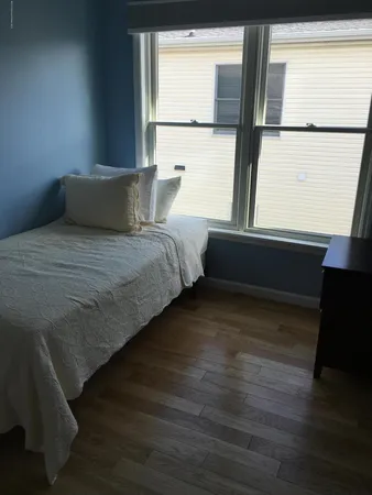 a bed sitting in a bedroom next to a window