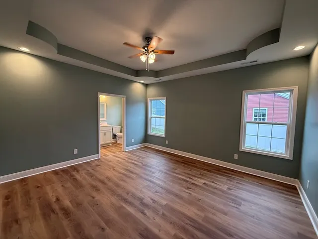 a view of an empty room with window and wooden floor