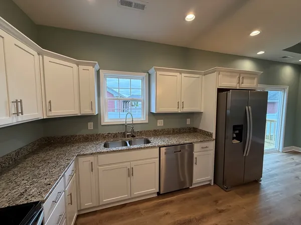 a kitchen with a sink a refrigerator and cabinets