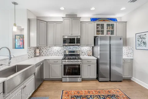 a kitchen with stainless steel appliances a stove a sink and a refrigerator