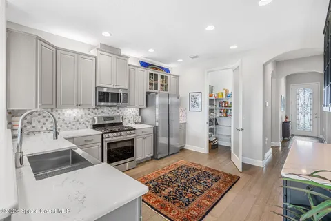 a kitchen with stainless steel appliances granite countertop a refrigerator stove oven and sink