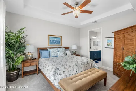 a bedroom with a large bed and a potted plant