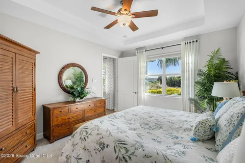 a bedroom with a bed window and a mirror