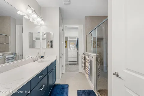 a spacious bathroom with a double vanity sink a mirror and a shower
