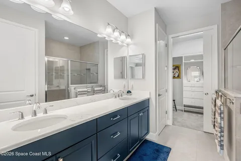 a bathroom with a double vanity sink a mirror and a shower