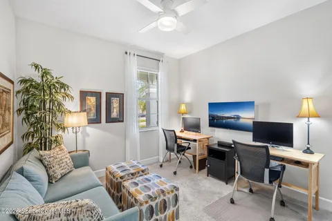 a living room with furniture a chandelier and a flat screen tv