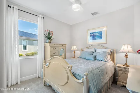 a spacious bedroom with a bed and a lamp