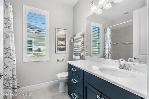 a bathroom with a sink a toilet and a large mirror