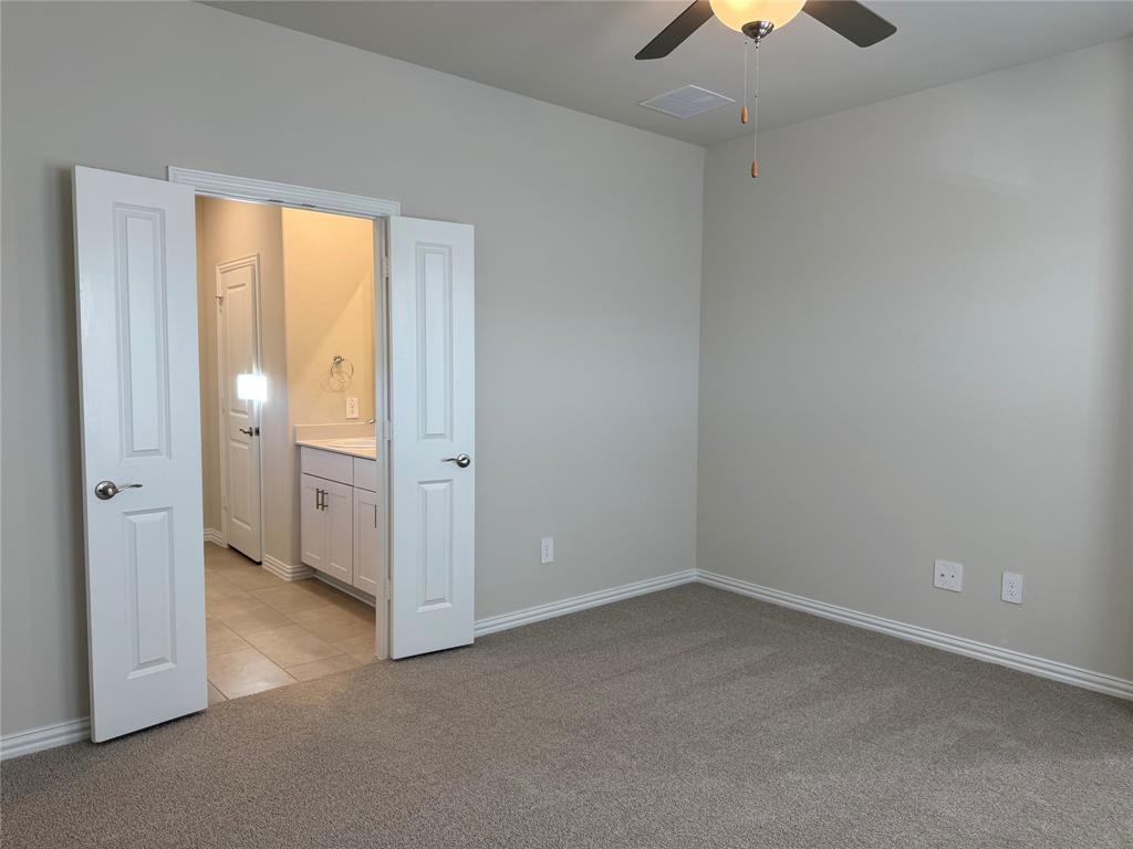 1736 Arches Road Anna, TX 75409 - Photo 6 of 18 Unfurnished bedroom with light colored carpet, ceiling fan, and ensuite bath