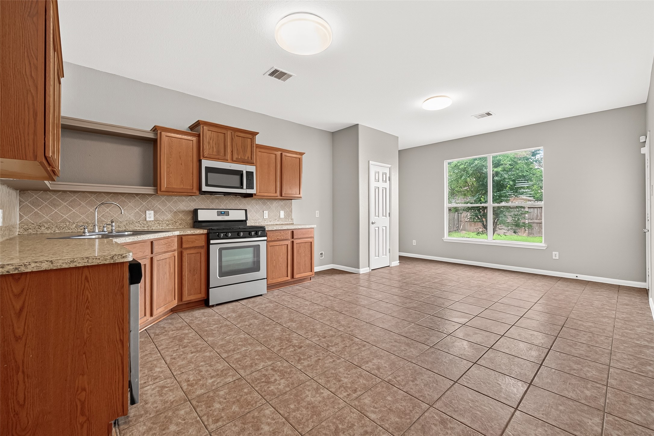 21327 Bella Flora Court Spring, TX 77379 - Photo 10 of 50 a kitchen with a stove a sink and a microwave