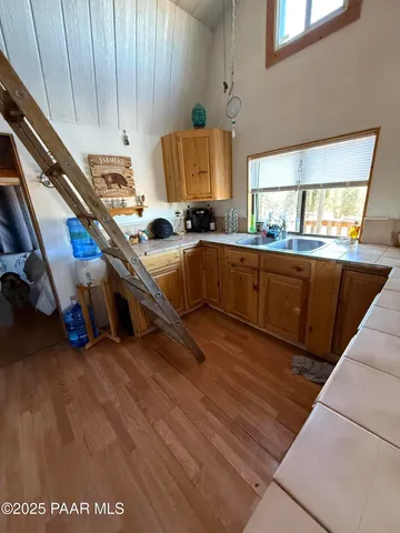 a kitchen with stainless steel appliances granite countertop a sink a stove and a wooden floors