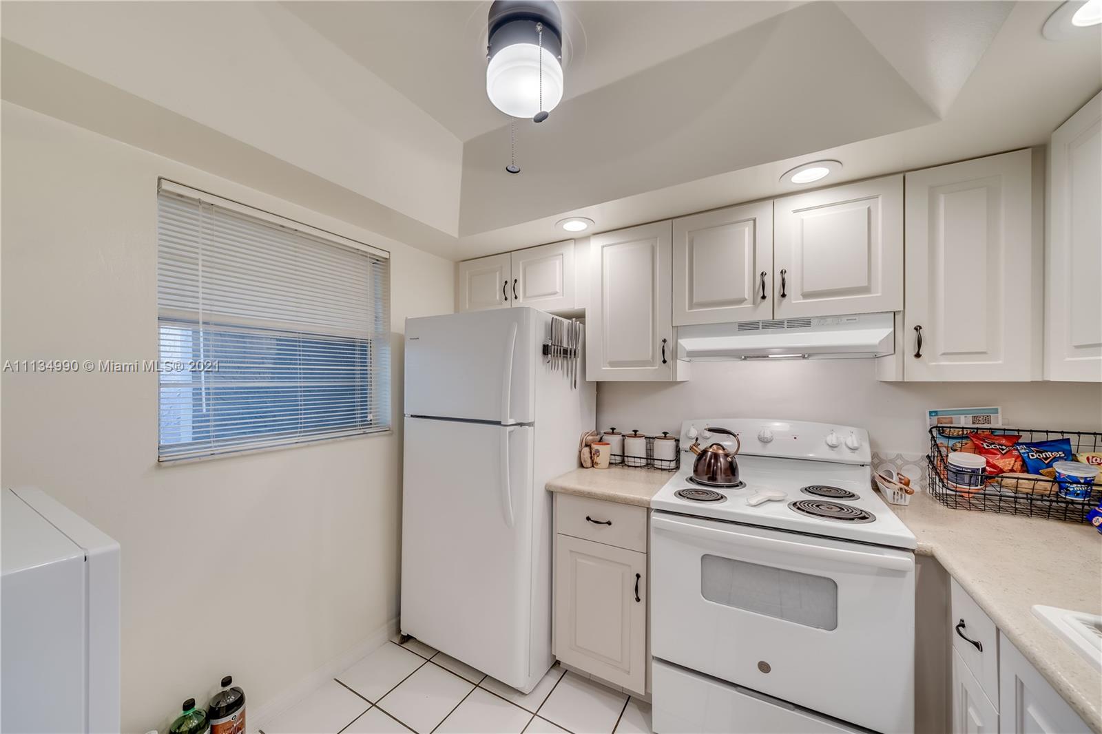 469 North Pine Island Road, Unit B305 Plantation, FL 33324 - Photo 13 of 38 a kitchen with stainless steel appliances white cabinets and white appliances
