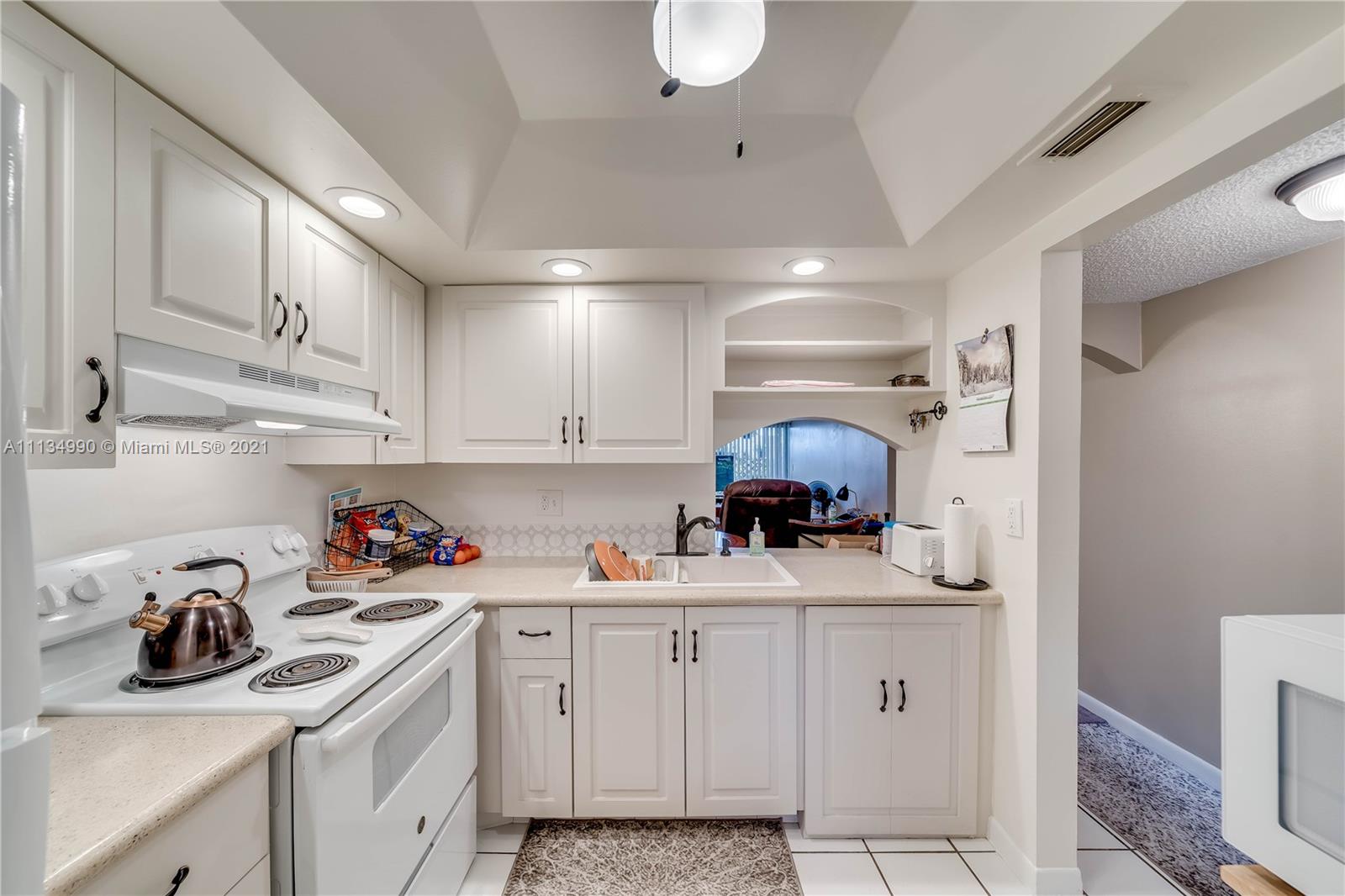 469 North Pine Island Road, Unit B305 Plantation, FL 33324 - Photo 14 of 38 a kitchen with white cabinets and appliances