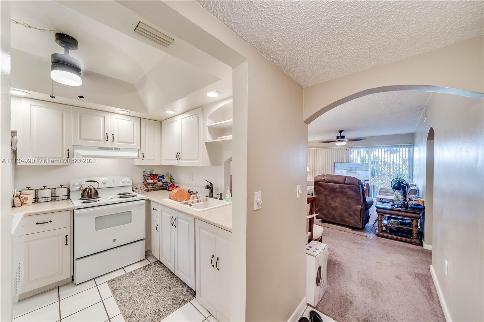 469 North Pine Island Road, Unit B305 Plantation, FL 33324 - Photo 10 of 38 a kitchen with a sink a stove cabinets and wooden floor