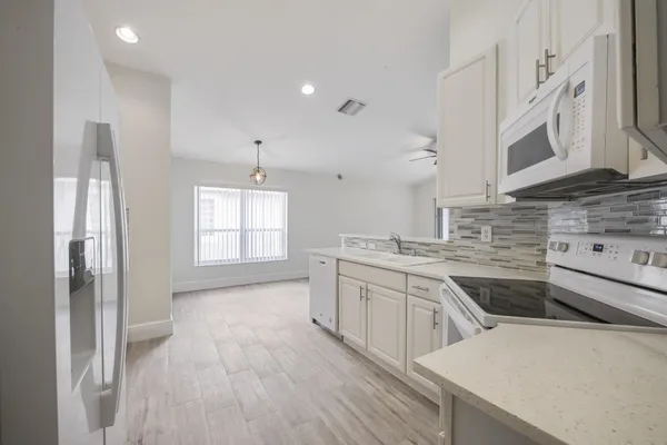 a kitchen with stainless steel appliances a sink stove and cabinets