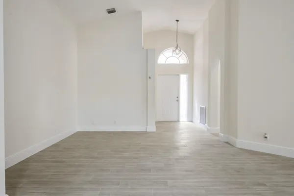 a view of a chandelier in big room and wooden floor