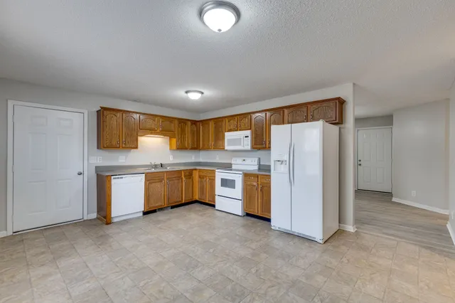 a front view of a house with a yard and trees