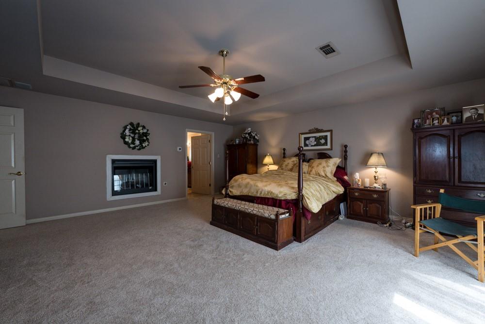 9554 David Fort Road Argyle, TX 76226 - Photo 24 of 35 a spacious bedroom with a bed and a chandelier