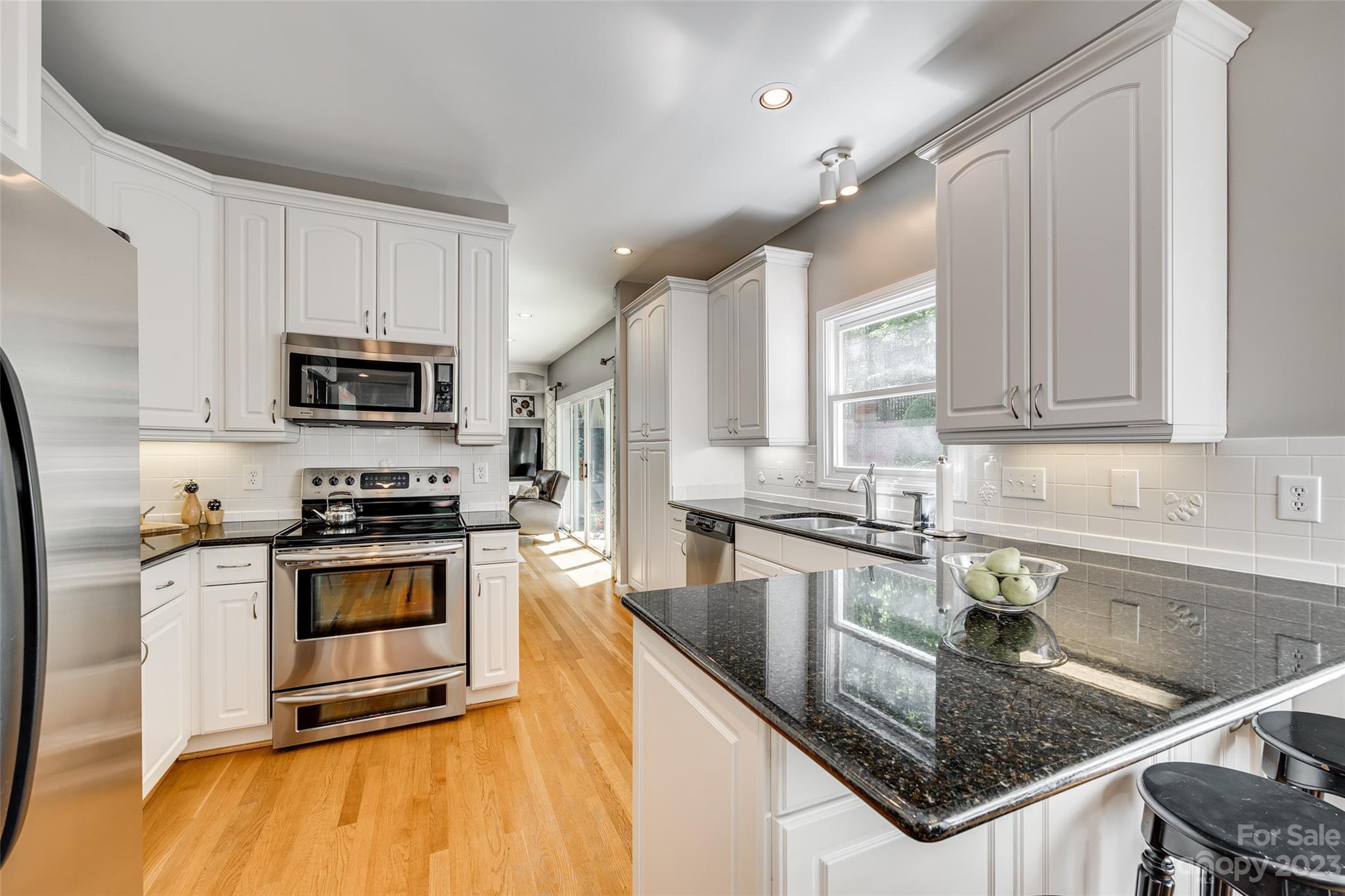 12005 Forest Garden Fort Mill, SC 29708 - Photo 15 of 48 a kitchen with stainless steel appliances granite countertop a stove a sink and a microwave