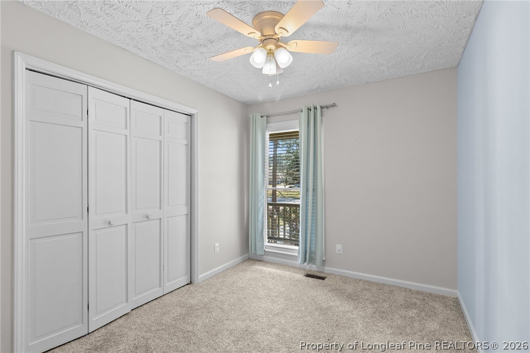 7756 Dragonhead Road Fayetteville, NC 28311 - Photo 27 of 42 an empty room with closet and a ceiling fan
