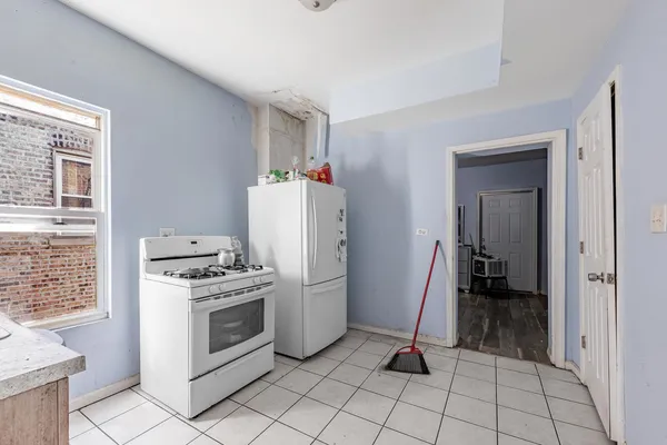 a kitchen with white cabinets a sink and a stove