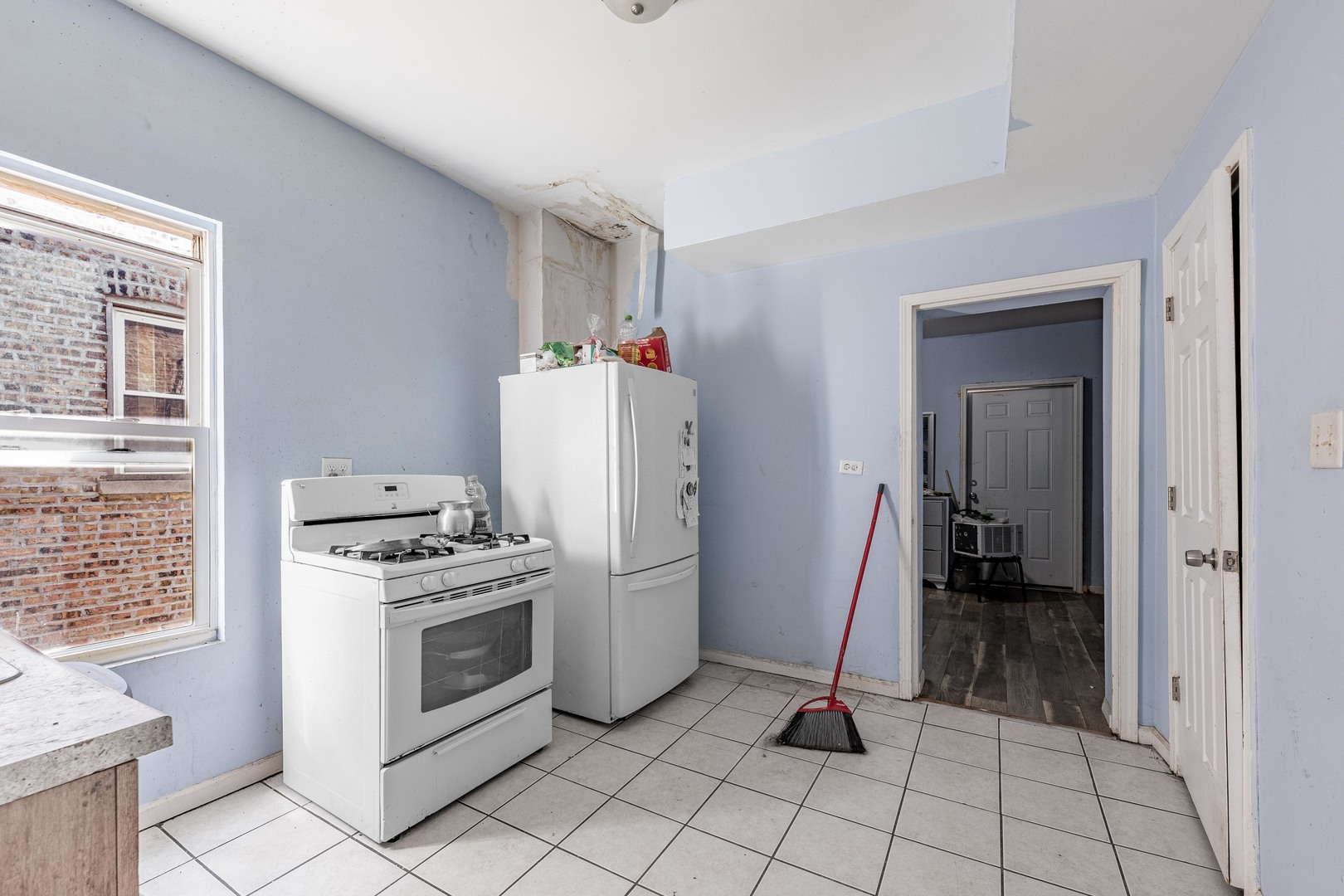 1638 South Pulaski Road Chicago, IL 60623 - Photo 16 of 22 a kitchen with white cabinets a sink and a stove
